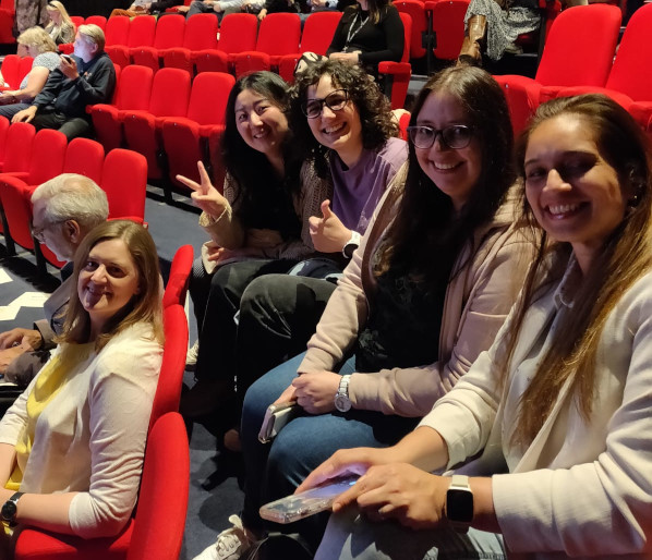 Laurie and lab members sitting in theatre seats at an awards ceremony